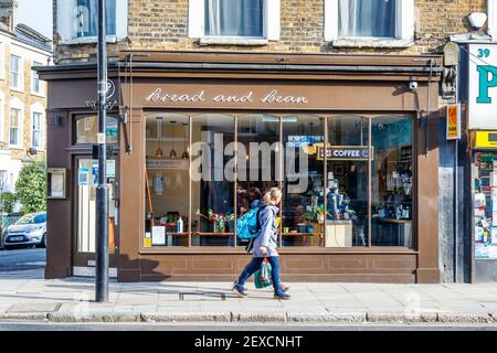 Zwei Frauen gehen an Bread and Bean vorbei, einem unabhängigen Café, das nur während der dritten Coronavirus-Sperre, Islington, London, Großbritannien, zum Mitnehmen geöffnet ist Stockfoto