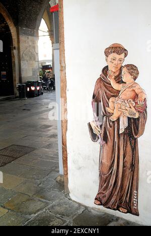 Anti-Vaxer vandalisieren Straßenkünstler Arbeit. Padua, Italien. Der Schriftsteller Evyrein malte kürzlich zwei Bilder des Heiligen Antonius, der eine große Pfizer-Impfspritze statt der Lilie an zwei verschiedenen Wänden in der Stadt hielt, um die Anti-Covid-Impfkampagne 19 zu fördern. Anti-vax-Leute kritisierten die Initiative heftig, ruinierten die Murales und drohten Evyrein in den sozialen Medien zu töten. Stockfoto