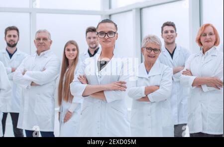 Junge Forscherin steht vor ihren älteren Kollegen. Stockfoto