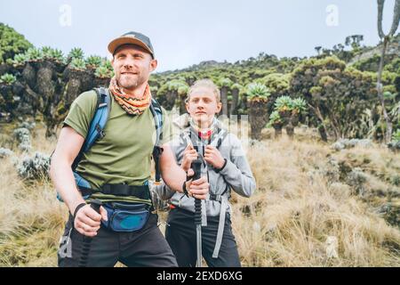 Vater und Teenager-Sohn als Backpacker haben Wanderung auf der Umbwe-Route im Wald zum Kilimanjaro Berg. Aktive Klettern Menschen und Reisen Stockfoto