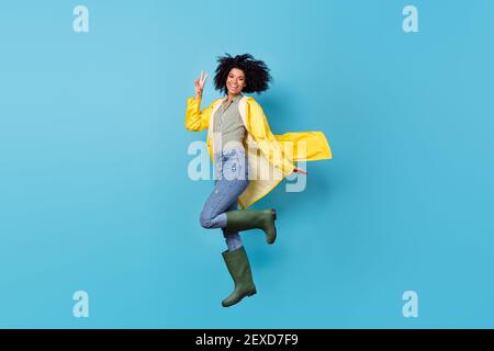 Full size-Profil-Foto von ziemlich sorglos dunkle Haut Mädchen Finger zeigen V-Zeichen haben Spaß isoliert auf blauem Hintergrund Stockfoto