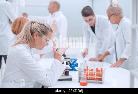 Wissenschaftlerin sitzt an einem Schreibtisch im Labor. Stockfoto