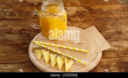 Ananassaft in einem Glas auf einem Holzhintergrund. Umschlag mit einem Brief Stockfoto