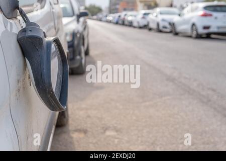 Nahaufnahme eines zerbrochenen Rückspiegels eines weißen Automobils An einer unbestimmten Stadtstraße Stockfoto