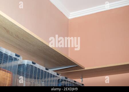 Holzregale, Stauraum im Ankleidezimmer mit beigen Wänden. Stockfoto