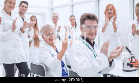 Eine Gruppe junger Wissenschaftler gratuliert ihrem Kollegen mit Applaus Stockfoto
