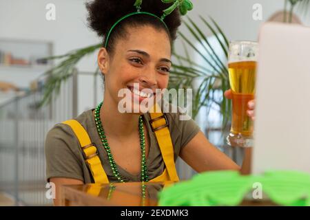 Happy Mixed Race Frau feiert st patrick's Tag machen Video Rufen Sie das Anheben eines Glases Bier an Stockfoto