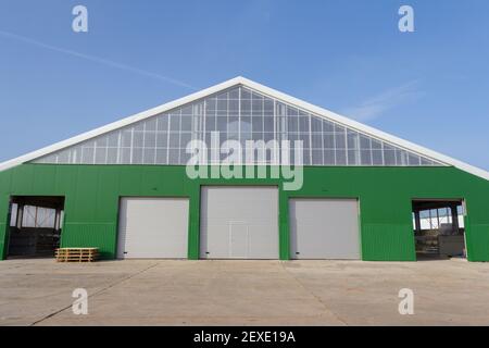 Gebäude im Bau mit Sandwichpaneel mit Dämmung an der Wand. Bau eines neuen Industriegebäudes. Stockfoto