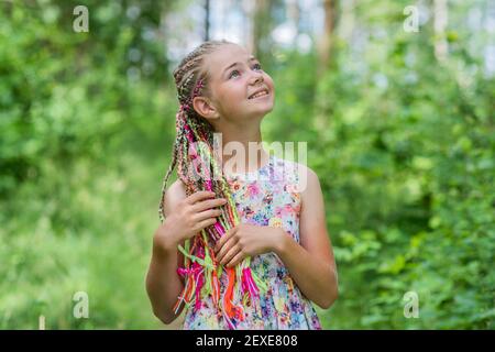 Teenager-Mädchen mit bunten Dreadlocks im Wald. Stockfoto