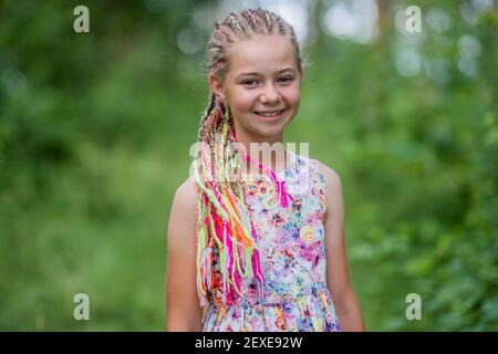 Teenager-Mädchen mit bunten Dreadlocks im Wald. Stockfoto