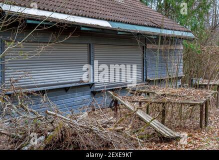 Lost Place, bewachsener Biergarten mit moosigen Sitzbereichen, Gasthof Obermühltal, Bayern, Deutschland, Europa Stockfoto