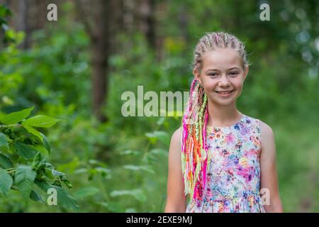 Teenager-Mädchen mit bunten Dreadlocks im Wald. Stockfoto