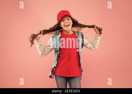 Ihr eigener Friseur. Happy girl halten lange Haare rosa Hintergrund. Kinderfriseur. Friseursalon für Kinder. Schönheitssalon. Friseursalon mit Friseursalon. Gönnen Sie sich einen großartigen Service. Stockfoto