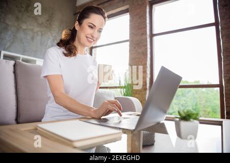 Foto von jungen glücklich gute Laune fröhlich lächelnd Mädchen arbeiten Entfernt in Laptop trinken Tee Kaffee zu Hause Stockfoto