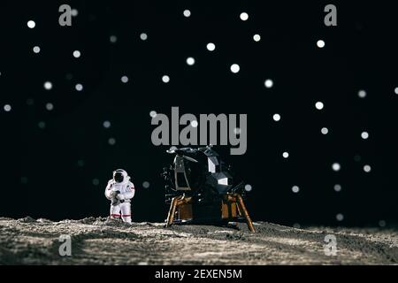 Ein Astronaut Miniaturspielzeug neben einem Raumschiff auf dem mond vor Bokeh Hintergrund Stockfoto