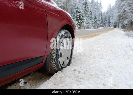Auto auf der Seite einer verschneiten, rutschigen Winterstraße. Track im Schnee. Gefährliche Fahrt auf einer vereisten Autobahn. Stockfoto