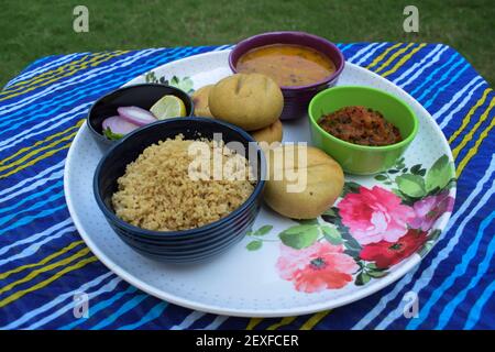 Rajasthani Traditionelles Essen Dal Baati auch bekannt als Dal Bati oder Daal Baati mit Churma oder Choorma und Zwiebel grünkältigen Salat, Knoblauch Gurke, Tomaten p Stockfoto