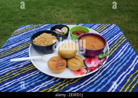 Rajasthani Traditionelles Essen Dal Baati auch bekannt als Dal Bati oder Daal Baati mit Churma oder Choorma und Zwiebel grünkältigen Salat, Knoblauch Gurke, Tomaten p Stockfoto