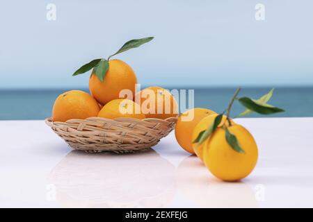 Frische Orange in einem Weidenkorb mit Blättern auf einem unscharfen Hintergrund. Selektiver Fokus. Vitamin- und gesundes Lebensmittelkonzept. Stockfoto