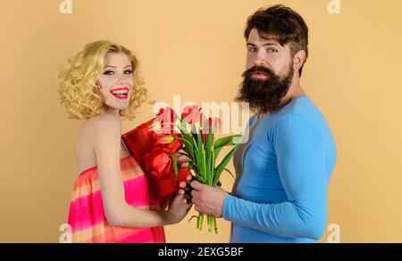 Freund gibt Blumenstrauß zu Freundin. Liebe, Beziehung, Dating, Jubiläum. Mann gratuliert Frau mit Geburtstag. Stockfoto