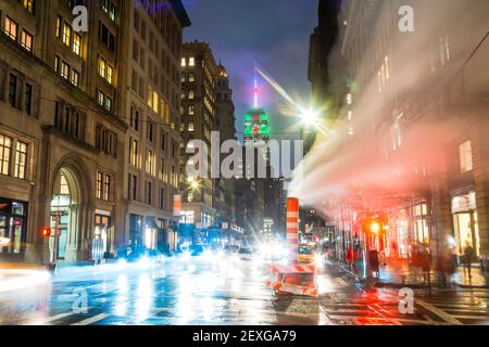 Das Empire State Building leuchtet während der Weihnachtsfeiertage in New York City unter den Gebäuden von Midtown Manhattan. Stockfoto