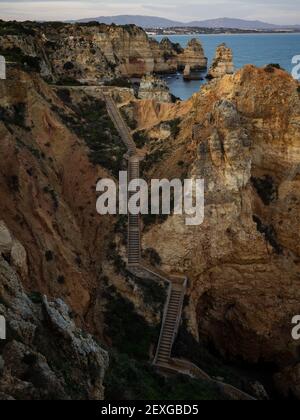 Holzsteg Treppen Pfad Treppe Sonnenuntergang Panoramablick auf Ponta da Piedade Strand Kap Meer Stapel Felsformationen in Lagos Algarve, Portugal EU Stockfoto