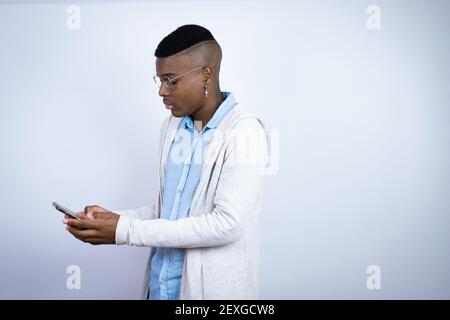 Junger schöner afroamerikanischer Mann trägt Freizeitkleidung Junge afrikaner amerikanischer Mann trägt ein legeres Hemd, das auf gelbem Hintergrund steht Chatten Stockfoto