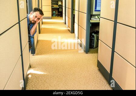 Gelangweilter Geschäftsmann in Bürokabine. Stockfoto