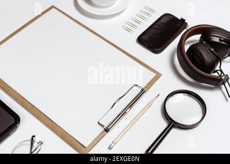 Flaches Lay von stilvollen männlichen Arbeitsplatz mit Clip-Ordner, Laptop und Business-Zubehör auf weißem Hintergrund Stockfoto