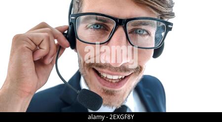 Lächelnder Geschäftsmann, der auf einem Headset gegen einen weißen Backgroun spricht Stockfoto