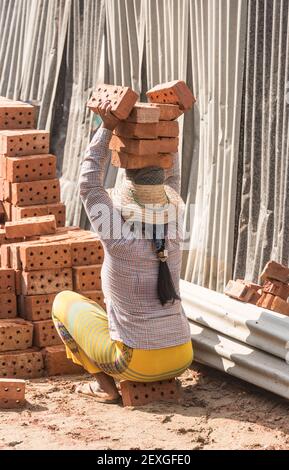 Frauen tragen Ziegelsteine auf einer Baustelle in Mandalay, Myanmar Stockfoto