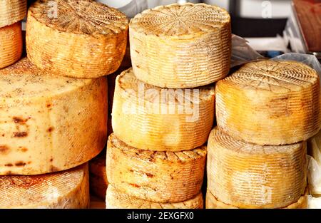 Auf der Theke gibt es einen Haufen kleiner, runder, geräucherter Ziegenkäse. Stockfoto