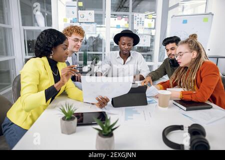 Multirassische IT-Spezialisten, die mit Grafiken und Diagrammen arbeiten Stockfoto