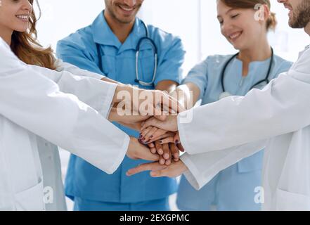 Ärzte und Krankenschwestern stapeln Hände. Konzept der gegenseitigen Hilfe. Stockfoto