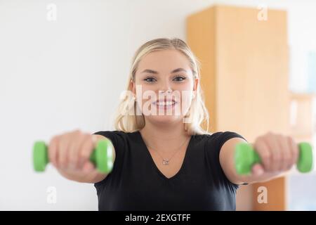 Junge Frau, die zu Hause Sport macht Stockfoto