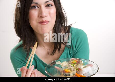 Exhuberante Frau Genießt Sushi-Mittagessen Stockfoto