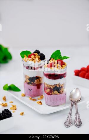 Beerenpudding mit frischen Beeren, Müsli und griechischem Joghurt im Glas. Stockfoto