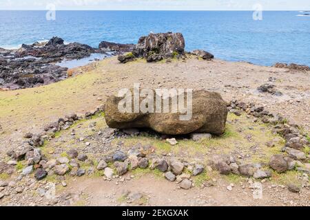 Ein verwitterter gestürzten Moai, der auf dem Boden in einem liegt Ring aus Steinen und Felsen bei Ahu Akahanga auf dem südküste der Osterinsel (Rapa Nui) Chile Stockfoto