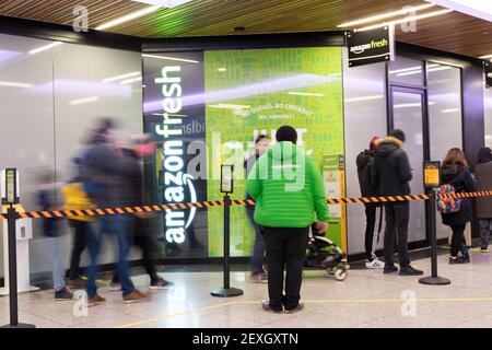 Das Personal begrüßt die Einkäufer in der Schlange zu Amazon Fresh. Es ist das erste Geschäft mit "Just Walk Out" in Ealing London, Großbritannien Stockfoto