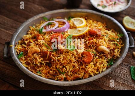 Hausgemachte Garnelen Shrimp biryani serviert mit Joghurt Raita und Rüben Gurkenscheibe Stockfoto