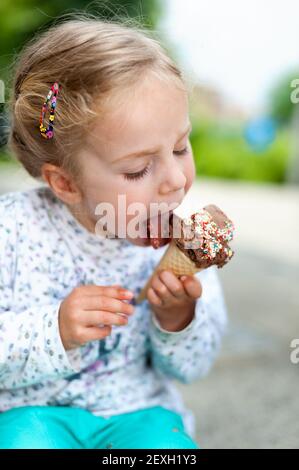 Süße kleine Mädchen essen Eis Stockfoto