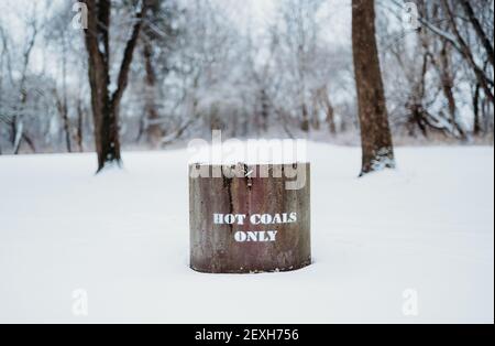 Ein heißer Kohleimer mit einer weißen 'heißen Kohle nur' Text in einem verschneiten Feld Stockfoto