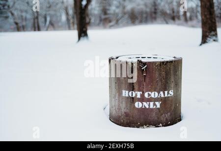 Ein heißer Kohleimer mit einer weißen 'heißen Kohle nur' Text in einem verschneiten Feld Stockfoto