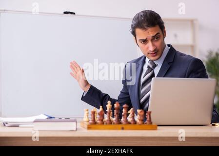 Junge Geschäftsmann Mitarbeiter spielen Schach am Arbeitsplatz Stockfoto