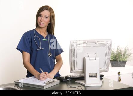 Arbeitende Krankenschwester füllt Diagramm am Arbeitsplatz Stockfoto