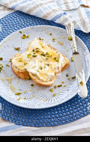 Brötchen mit Frischkäse und Honig Stockfoto