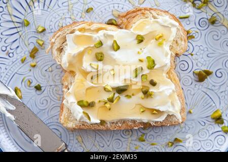 Brötchen mit Frischkäse und Honig Stockfoto