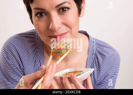 Candid Schließen Porträt Cute Brunette Frau Rohkost Sushi Mittagessen Stockfoto