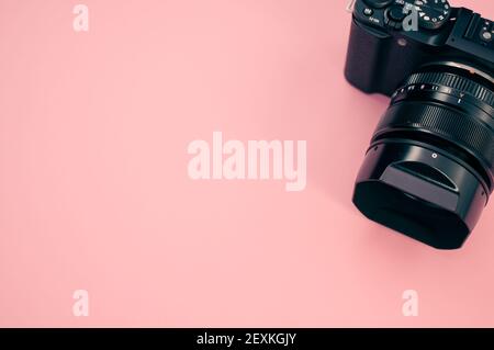 Eine Draufsicht auf eine Kamera auf einem pastellrosa Fläche für einen Kopierbereich Stockfoto
