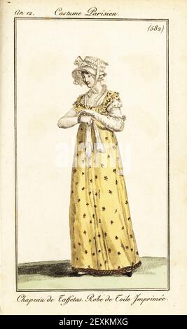 Modische Frau in Taft Haube und gedruckt gelb toile Kleid. Chapeau de Taffetas, Robe de Toile Imprimee. Handkolorierter Kupferstich aus Pierre de la Mesangeres Journal des Dames et des Modes, Magazine of Women and Fashion, Paris, an 12, September 1804. Illustrationen von Carle Vernet, Jean-Francois Bosio, Dominique Bosio und Philibert Louis Debucourt, gestochen von Pierre-Charles Baquoy. Stockfoto